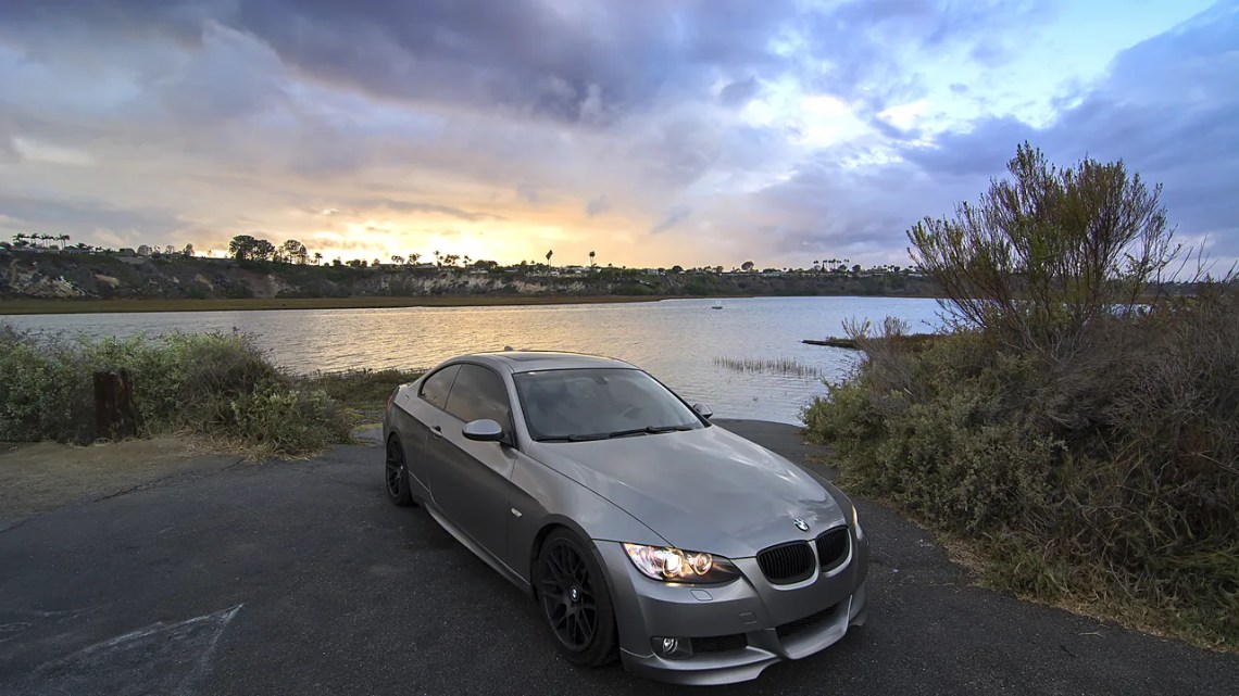BMW E92 335i Gray BMW E92 335i coupe parked by a lagoon at sunset