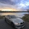 Gray BMW E92 335i coupe parked by a lagoon at sunset