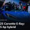 Blue Chevrolet Corvette E-Ray with a roof-mounted ski rack at an auto show, with a caption band reading 2025 Corvette E-Ray 655-hp hybrid