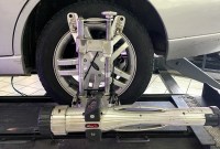 Wheel alignment sensor Wheel alignment sensor clamped to the front wheel of a silver Ford Focus on an alignment rack