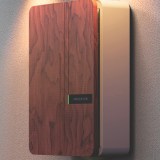 side view of an Andersen A3 with a beige and wood veneer finish mounted to a wall, lit by outdoor wall lights