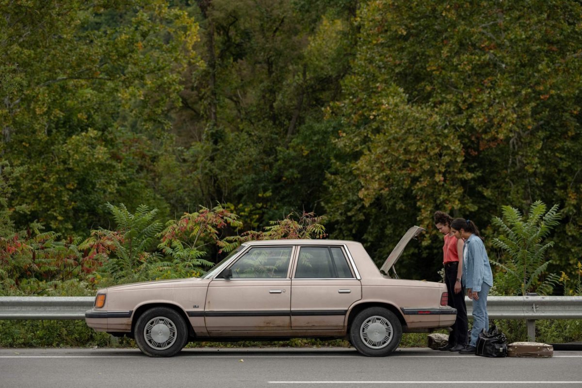 Marian and Jamie look into the trunk of their car.