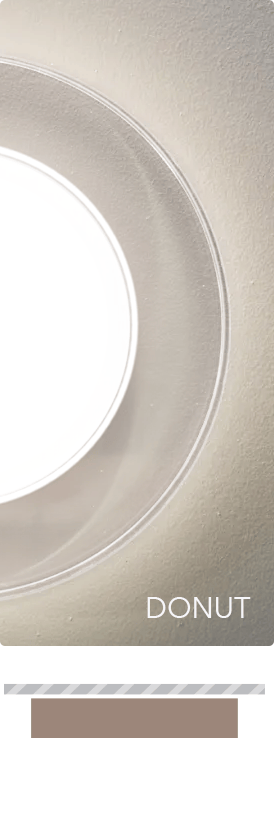 Fluent Lighting Donut surface-mounted luminaire with a luminous center surrounded by a clear acrylic ring that adds optical depth, internal reflection, and visual cutoff.