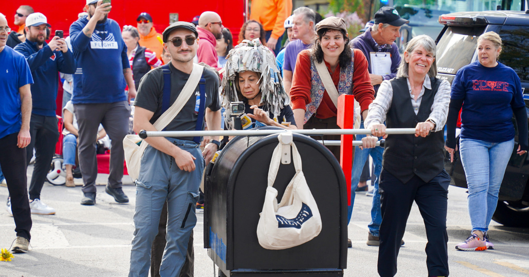 Four people and a casket on wheels