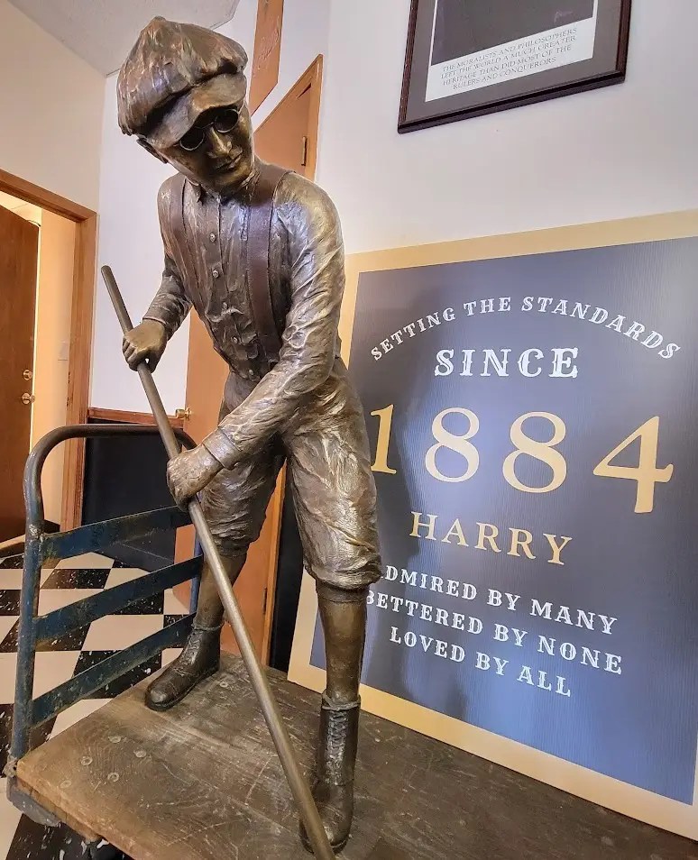Showing a bronze statue of Harry Truman with a sign next to him showing "Since 1884"
