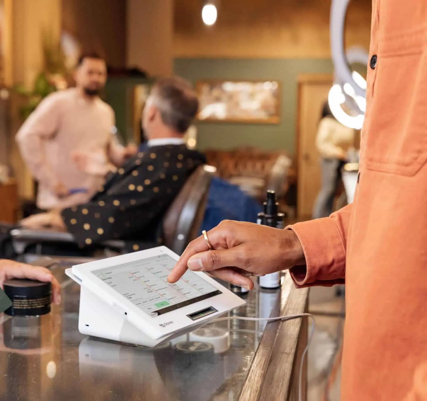 Customer using Clover Mini POS system to pay at a salon checkout counter