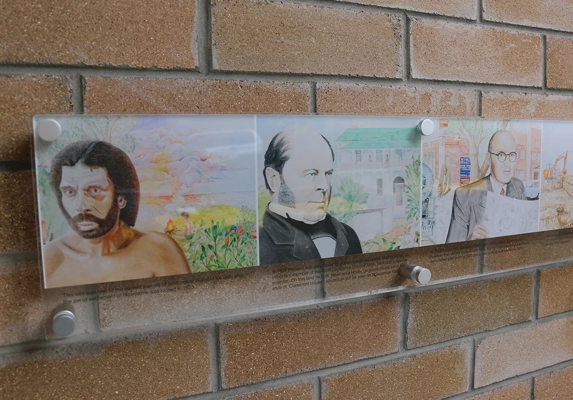 A plaque highlight key aspects of the mural depicting historic events in Newcastle, Australia