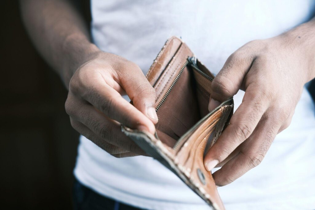 Man opening an empty wallet before looking for convenient ATM access nearby.