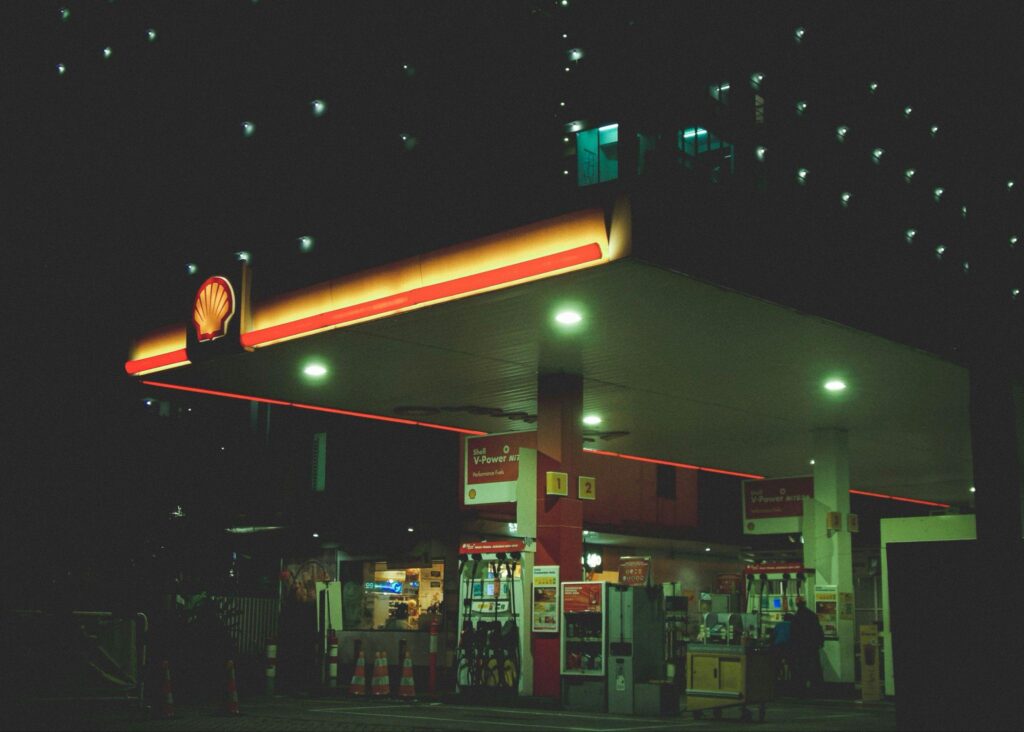 Shell gas station illuminated at night with fuel pumps and convenience store signage 