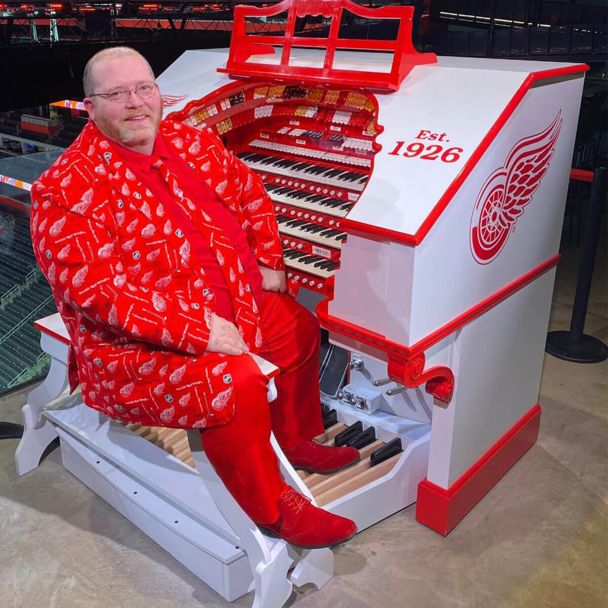 Dave at the redwings organ in a fully red wings branded suit.