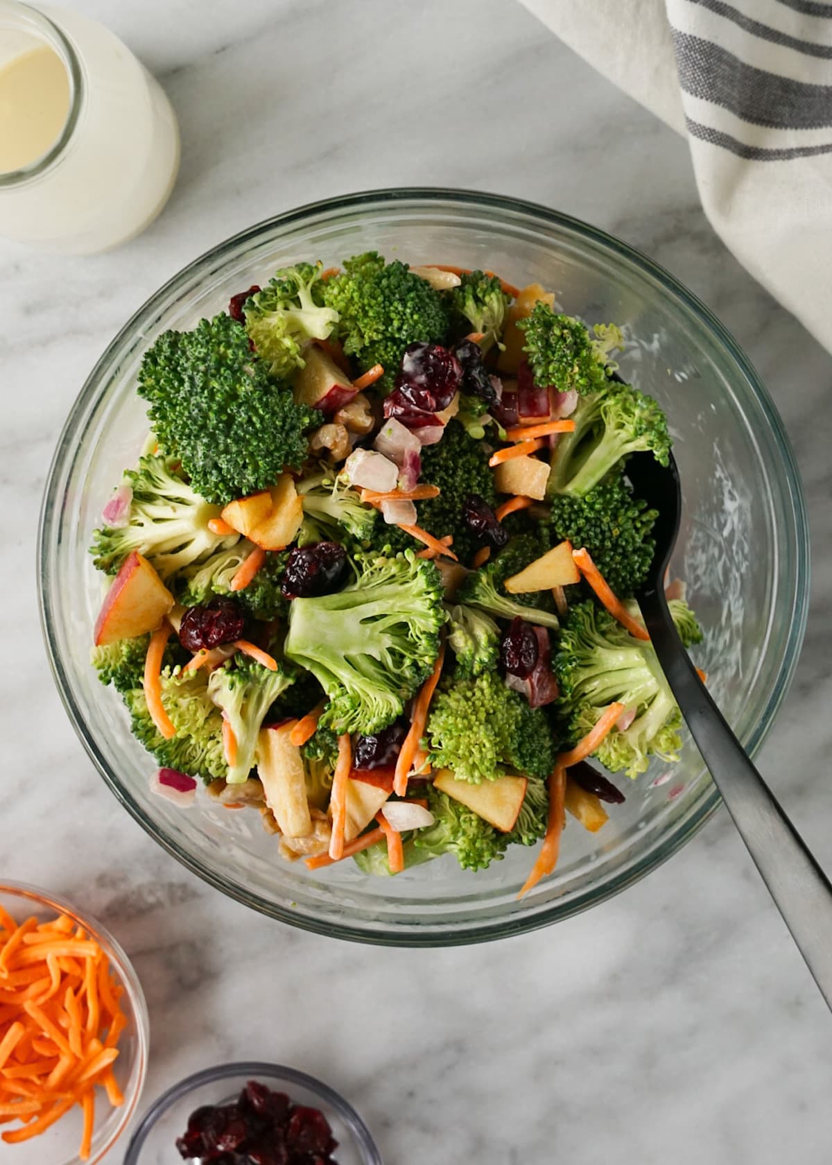 Broccoli Crunch Salad in a mixing bowl with black spoon.