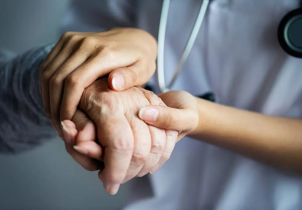 Nurse holding patient hand | Hocking Valley Community Hospital