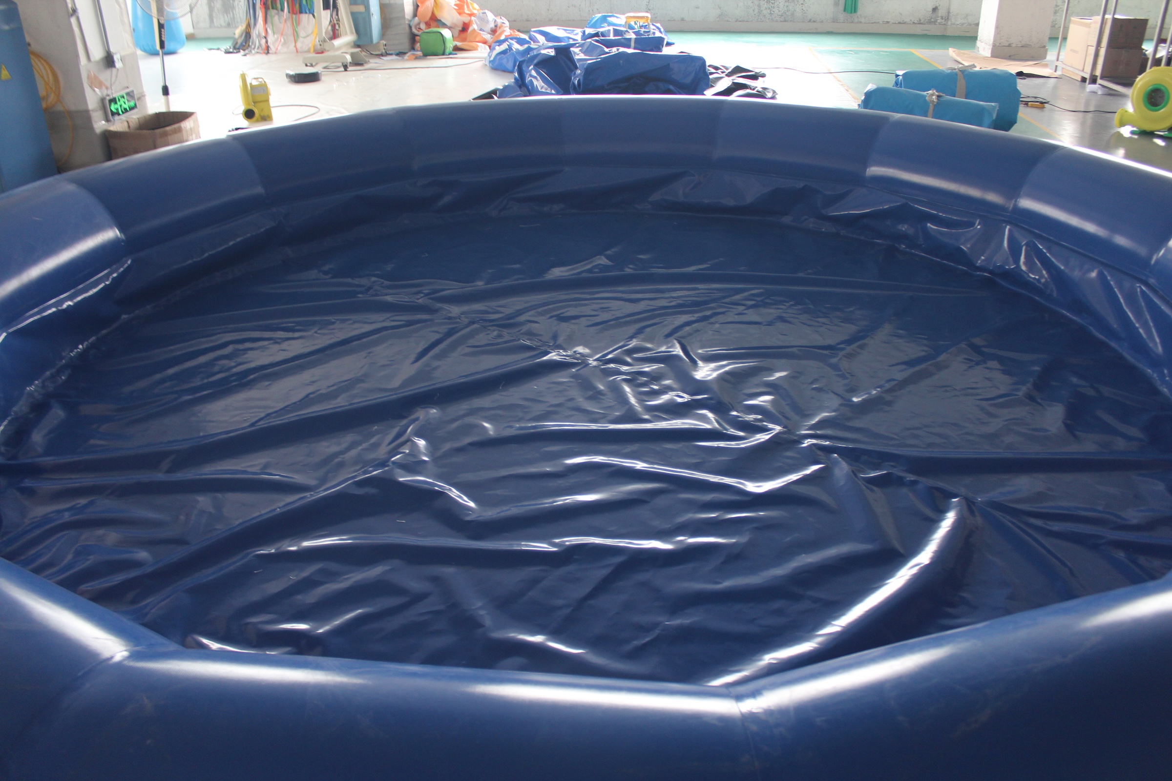 Interior close-up view of a blue inflatable round pool showing the PVC floor base and inner wall seams