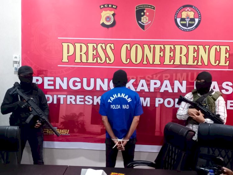 AB atau Toke AW, yang diterapkan sebagai tersangka aktor intelektual penembakan dua petani warga Indrapuri, dikawal ketat oleh dua polisi di Mapolda Aceh, Senin (6/6)