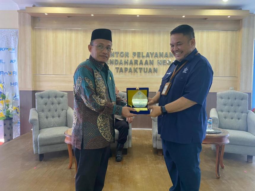 Kepala KPPN Tapaktuan Andi Khairuddin menyerahkan plakat penghargaan kepada H Juniazi, SAg MPd sebagai KPA Inspiratif Jajaran KPPN Tapaktuan TA 2022, Kamis (14/7) di Aula KPPN setempat