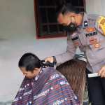 Aipda Denis Siswanto, sosok polisi yang menjadi Bhabinkamtibmas di Polsek Langsa Barat, Polres Langsa memberikan layanan pangkas gratis untuk warga desa