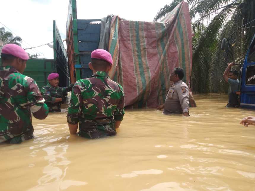 Sejumlah personel Marinir dan Polisi Pos Batas Polsek Kejuruan Muda bersama warga membantu evakuasi kendaraan terjebak banjir di perbatasan Kabupaten Aceh Tamiang-Sumut, Sabtu (5/11)