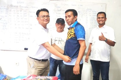 Acting GM SBA Anwar Bakti disaksikan Ketua PWI Aceh Nasir Nurdin memakaikan secara simbolis kostum cabang olahraga bridge kepada T Haris Fadhillah, Wakabid Kerja Sama PWI Aceh di kantor PWI Aceh, Rabu (16/11)