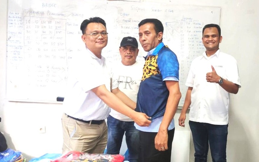 Acting GM SBA Anwar Bakti disaksikan Ketua PWI Aceh Nasir Nurdin memakaikan secara simbolis kostum cabang olahraga bridge kepada T Haris Fadhillah, Wakabid Kerja Sama PWI Aceh di kantor PWI Aceh, Rabu (16/11)