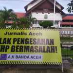 AJI Kota Banda Aceh memasang spanduk ke kantor Gubernur Aceh dan gedung DPRA sebagai bentuk penolakan terhadap pengesahan RKUHP menjadi UU, Selasa (6/12)