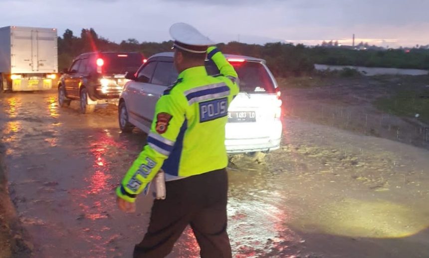 Polisi dari Satlantas Polresta Banda Aceh Polsek Baitussalam dan Polsek Krueng Raya melakukan pengaturan arus lalu lintas di sepanjang jembatan Gampong Lamnga-Lam Ujong, Kecamatan Mesjid Raya, Aceh Besar, Ahad (29/1)