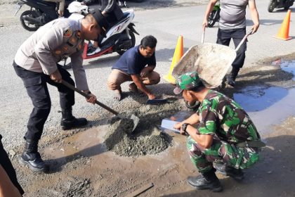 Kapolsek Ulee Kareng bergerak cepat mengajak anggota kepolisian yang bertugas di Polsek Ulee Kareng untuk menambal jalan berlubang di Gampong Lambhuk, Kecamatan Ulee Kareng, Kamis (2/2/2023). Foto: Dok. Polsek Ulee Kareng