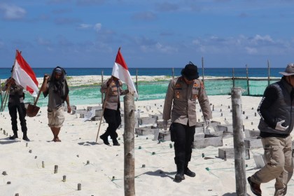 Kapolres Simeulue AKBP Jatmiko sambil membawa bendera merah putih tampak melakukan patroli di pulau terluar di Pulau Salaut