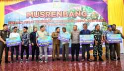 Pj Bupati Aceh Besar Muhammad Iswanto menyerahkan bantuan kepada penerima manfaat kompensasi kematian ternak akibat wabah PMK/LSD di Aceh Besar, Senin (13/3)