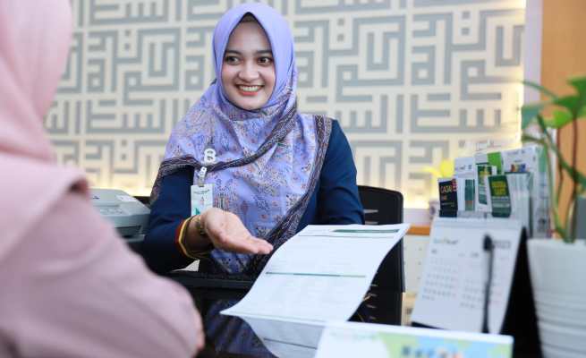 Karyawati Bank Aceh Syariah melayani nasabah di Kantor Bank Aceh Cabang Banda Aceh, Selasa (21/3)