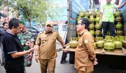 Pj Bupati Aceh Besar Muhammad Iswanto didampingi Kepala Dinas Koperasi dan UMKM Aceh Besar Darmansyah memantau operasi pasar murah Gas Elpiji 3 Kg, di halaman Meunasah, Lambaro, Kecamatan Ingin Jaya, Selasa (2/5)