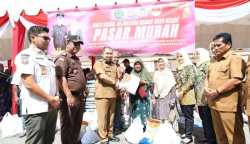 Pj Bupati Aceh Besar Muhammad Iswanto bersama Kajari Aceh Besar Basril G SH MH menyerahkan secara simbolis belanjaan warga di pasar murah yang digelar Pemkab Aceh Besar bekerja sama dengan Kejari setempat, di Kota Jantho Selasa (18/7)