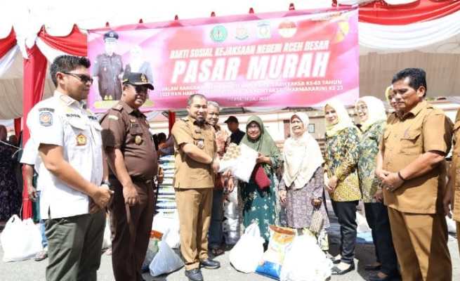 Pj Bupati Aceh Besar Muhammad Iswanto bersama Kajari Aceh Besar Basril G SH MH menyerahkan secara simbolis belanjaan warga di pasar murah yang digelar Pemkab Aceh Besar bekerja sama dengan Kejari setempat, di Kota Jantho Selasa (18/7)