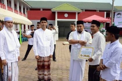 Pj Bupati Aceh Besar Muhammad Iswanto menyerahkan beasiswa santri secara simbolis usai upacara Hari Santri Nasional 2023, di Komplek Dayah Darul Muta'allimin Gampong Meulayo, Kecamatan Blang Bintang, Senin (23/10)