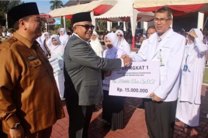 Sekda Aceh Bustami Hamzah didampingi Kadis Kesehatan Aceh dr Munawar SpOG menyerahkan penghargaan kepada tenaga kesehatan pada peringatan HKN ke-59 di Kantor Gubernur Aceh, Senin (13/11)