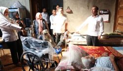 Kadis Sosial Aceh Muslem Yacob menyerahkan bantuan kursi roda dan tongkat ketiak untuk dua warga Gampong Lampulo, Kecamatan Kuta Alam, Banda Aceh, Rabu (10/1)