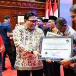 Pimpinan Ombudsman RI, Dadan S. Suharmawijaya menyerahkan Penghargaan dan Sertifikat Penganugerahan Predikat Penilaian Kepatuhan Penyelenggaraan Pelayanan Publik kepada Asisten III Pemkab Aceh Besar Jamaluddin, MM di Ajong Mon Mata, Banda Aceh, Kamis (25/1)