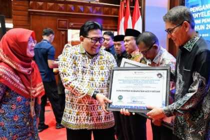 Pimpinan Ombudsman RI, Dadan S. Suharmawijaya menyerahkan Penghargaan dan Sertifikat Penganugerahan Predikat Penilaian Kepatuhan Penyelenggaraan Pelayanan Publik kepada Asisten III Pemkab Aceh Besar Jamaluddin, MM di Ajong Mon Mata, Banda Aceh, Kamis (25/1)