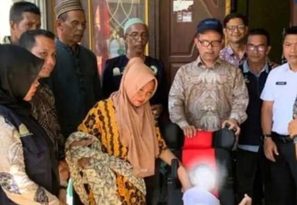Kadis Sosial Aceh Muslem Yacob menyerahkan kursi roda kepada bocah penderita Cerebral Palsy di Panteraja, Pidie Jaya, Kamis (1/2)