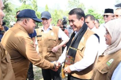 Sekda Aceh Besar Sulaimi menyambut Menteri Pertanian RI Andi Amran Sulaiman dengan mengalungkan sal saat tiba di Demplot Yonif 112/DJ di Gampong Deunong, Kecamatan Darul Imarah, Aceh Besar. (6/2/2024). (Foto: Dok. MC ACEH BESAR)