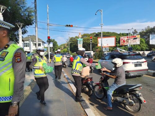 Personel Ditlantas Polda Aceh membagikan 100 paket takjil atau penganan berbuka puasa kepada pengendara atau pengguna jalan di Simpang Jam, Banda Aceh, Selasa, 19 Maret 2024