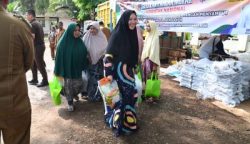 Nurlina saat membawa pulang paket pangan murah, di Mesjid Baitul Kiram, Peukan Biluy, Kecamatan Darul Kamal, Kabupaten Aceh Besar, Senin (1/4/2024). (FOTO/MC ACEH BESAR)