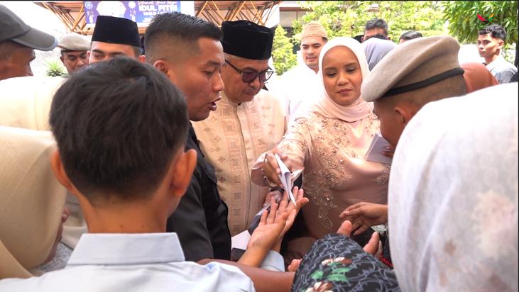 Pj Gubernur Aceh Bustami Hamzah bersama istri Mellani Subarni membagikan amplop Idul Fitri kepada para bocah pada Open House di Anjong Mon Mata Meuligoe Gubernur Aceh, Rabu (10/4)