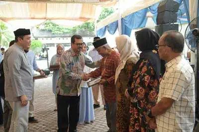 Pj Sekda Aceh Azwardi Abdullah menyerahkan piagam penghargaan purna tugas kepada pegawai RSUDZA pada Halal Bihalal Idul Fitri 1445 Hijriah di Lapangan rumah Parkir RSUDZA Banda Aceh, Sabtu (20/4)