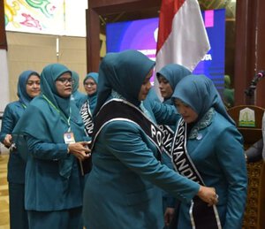 Pj Ketua TP PKK Aceh Mellani Subarni menyematkan selempang Posyandu kepada Pj Ketua Pembina Posyandu Aceh Besar Cut Rezky Handayani, usai pengukuhan ldi Anjong Mon Mata Pendopo Gubernur Aceh, Rabu (24/4)