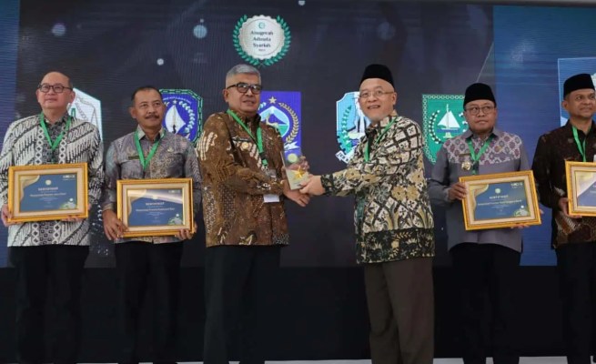 Plt Direktur Eksekutif KNEKS Taufik Hidayat menyerahkan penghargaan kepada Pj Gubernur Aceh Bustami Hamzah, di Menara Syariah, Pantai Indah Kapuk 2, Tangerang, Banten, Senin (20/5). (Foto: Humas BPPA)