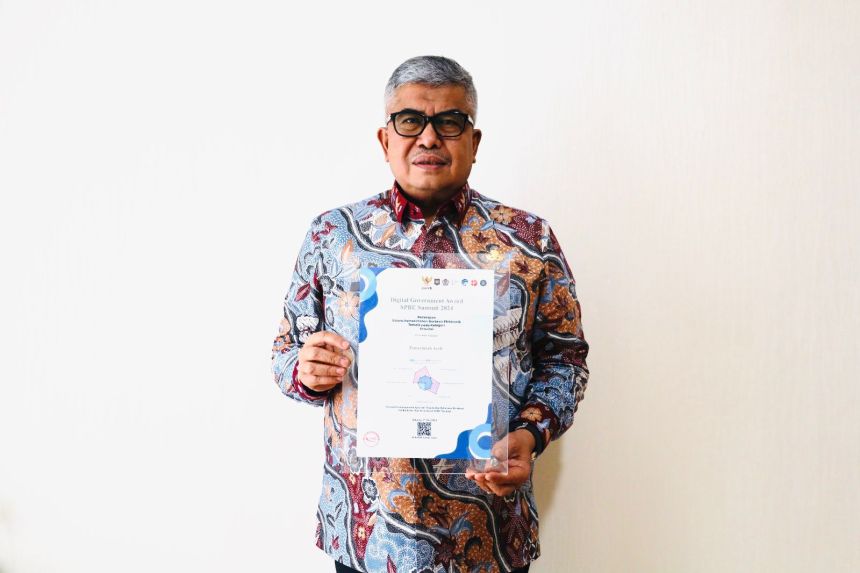 Pj Gubernur Aceh Bustami Hamzah memperlihatkan penghargaan Digital Goverment Award (DGA) Summit 2024. (Foto: For Infoaceh.net)