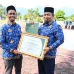 Pj Bupati Aceh Besar Muhammad Iswanto menerima penghargaan dari Kemendes RI atas kepedulian terhadap Pengembangan Teknologi Tepat Guna yang diserahkan Kadis DPMG Aceh Besar Carbaini di halaman Kantor Bupati, Aceh Besar, Selasa (23/7). Foto: Istimewa