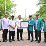 Pj Bupati Aceh Besar Muhammad Iswanto menerima sertifikat ucapan terima kasih dari Rektor USK diserahkan Wakil Rektor IV USK, di halaman Dekranasda, Gampong Gani, Kecamatan Ingin Jaya, Aceh Besar, Rabu (7/8). (FOTO/MC ACEH BESAR)