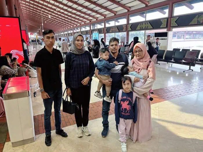 Rahmatul Ula (kanan) bersama tiga anaknya, yang didampingi staf BPPA saat dipulangkan ke Aceh, di Bandara Soekarno Hatta, Tangerang, Kamis, 15 Agustus 2024. (Foto: Humas BPPA)