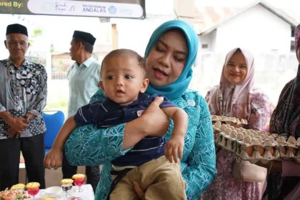Pj Ketua Tim Penggerak PKK Aceh Safriati tampak akrab dengan anak saat membuka kegiatan Edukasi dan Sedekah Pangan dalam rangka Hari Pangan Dunia di Gampong Limpok, Darussalam, Jum'at (18/10/2024).